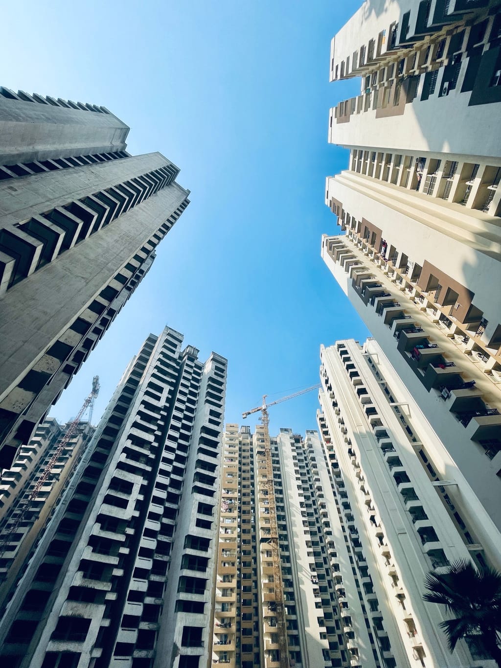 A new high-rise standing clean against an open blue sky.