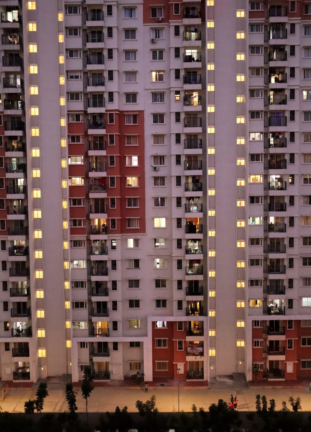 A pink apartment tower, balcony after balcony, homes stacked to the top.